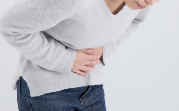 お腹の不調に悩む女性