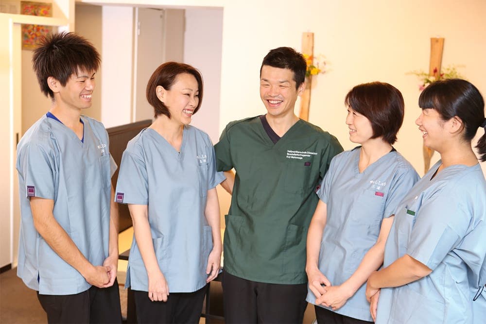 肉離れ施術後にスタッフと笑顔の患者