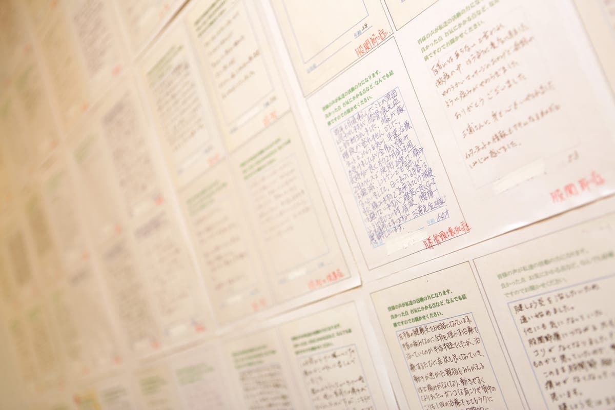 Handwritten postcards from clients displayed on the wall at a Yurashi location